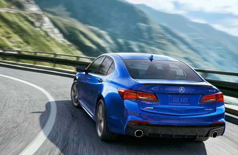 rear view of a blue 2018 Acura TLX on a curvy road