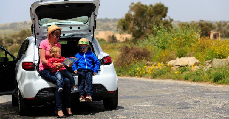 family looking at map resting in a compact crossover cargo area