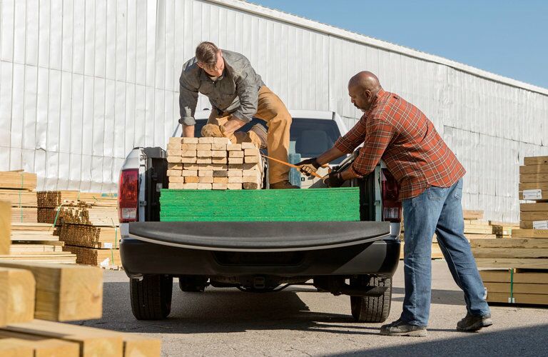 People loading wood into the 2018 Ram 1500