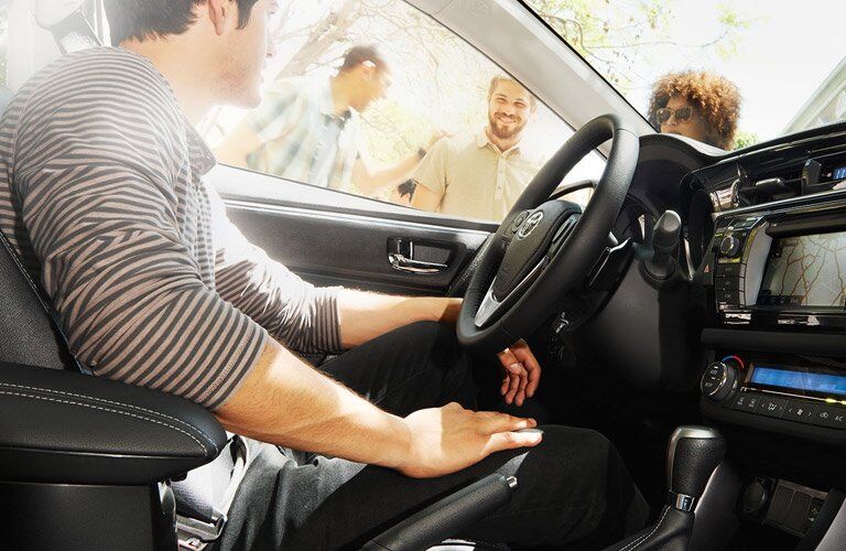 Driver of 2017 Toyota Corolla talking to friends out the window