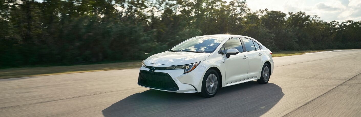 white 2020 Toyota Corolla driving down road