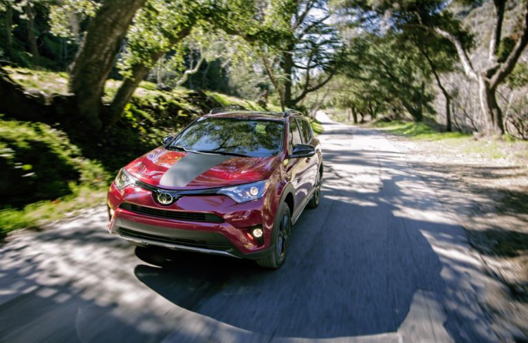 An elevated photo showing the front left quarter of the 2018 Toyota RAV4 Adventure driving on the road.
