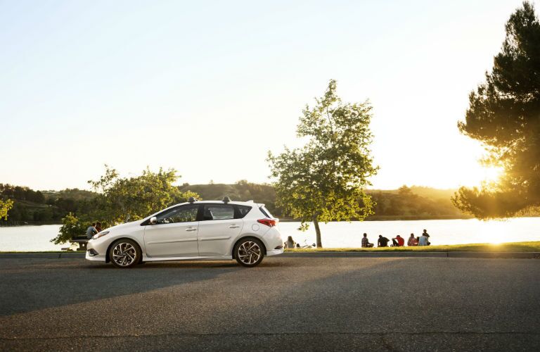 A photo of the 2018 Corolla iM near a park and a lake.
