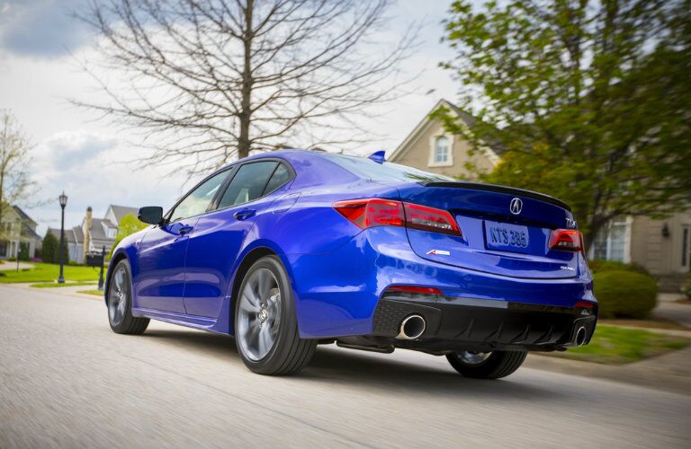 Rear view of blue 2019 Acura TLX driving on residential road