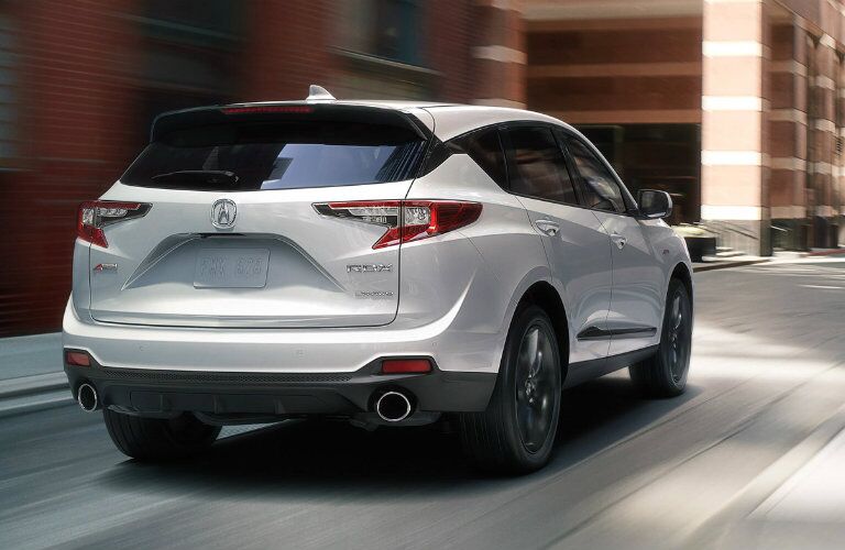 Rear view of white 2019 Acura RDX driving on city street