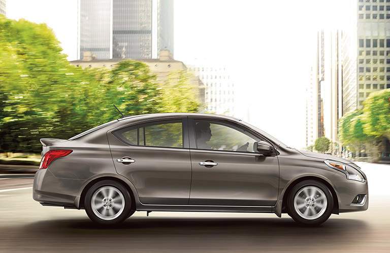 silver 2017 nissan versa driving on city street