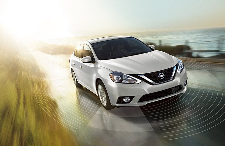 white 2018 nissan sentra driving on coastal road