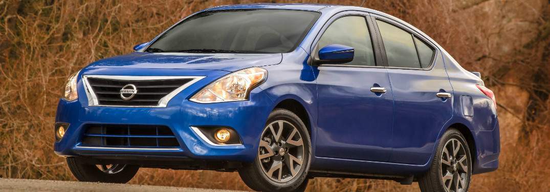 blue 2017 nissan versa against forest background