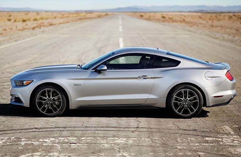 side view of a silver 2017 Ford Mustang on a desert road