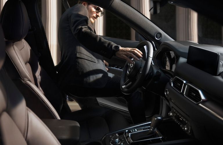 A man getting into the driving seat of the 2021 Mazda CX-5