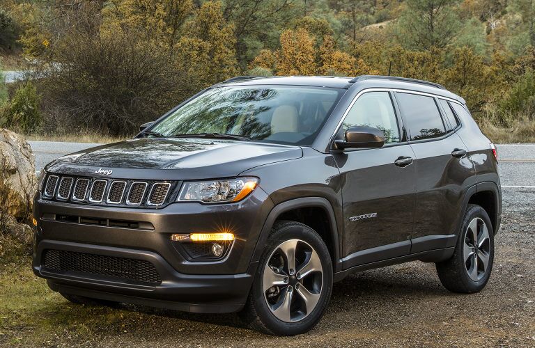 A photo of a used Jeep Compass parked in the woods.