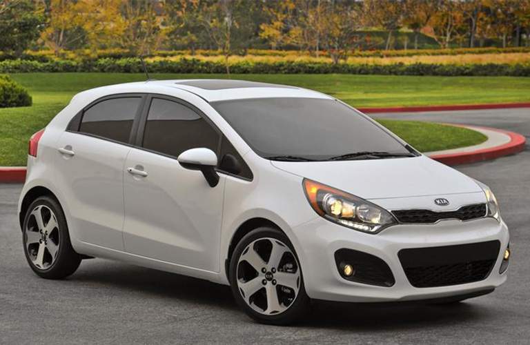 A white Kia Rio5 example in front of a field of flowers