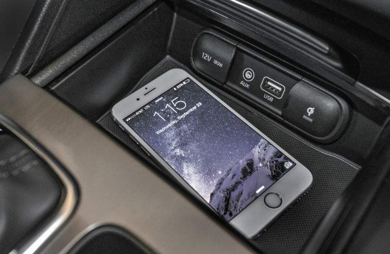 A photo of a smartphone in a tray located in the front of a 2018 Optima