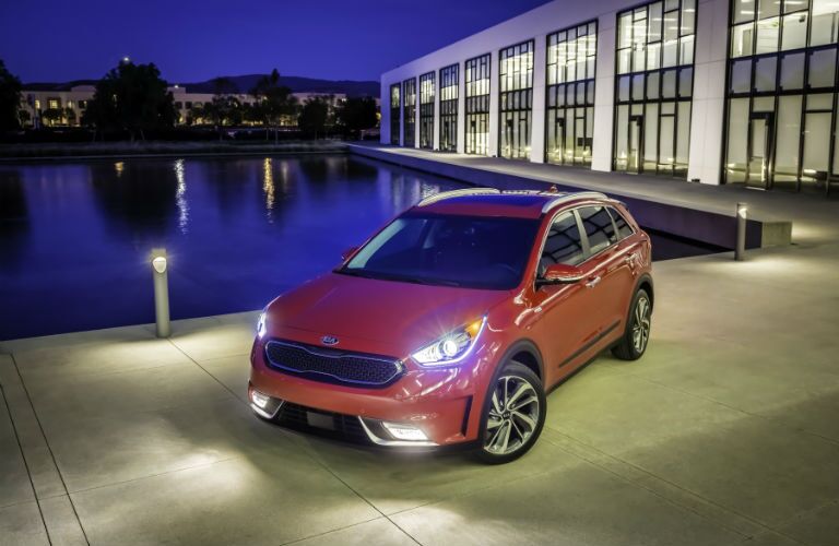 A front left quarter photo of the 2018 Kia Niro with its lights turned on.