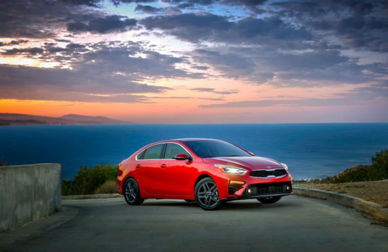 A front right profile photo of the 2019 Kia Forte parked in front of the ocean.