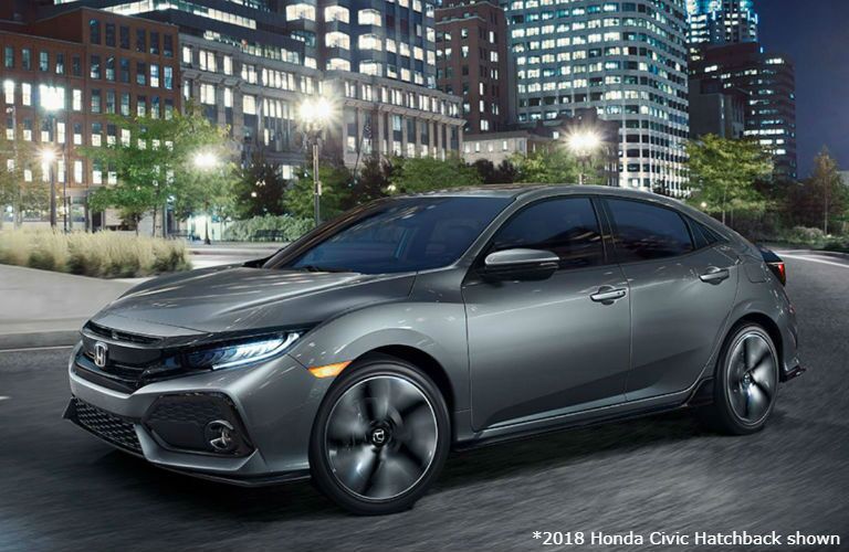 2018 Honda Civic Hatchback driving around a city at night