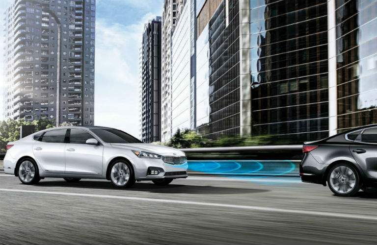 silver 2018 kia cadenza driving on city highway with smart cruise control