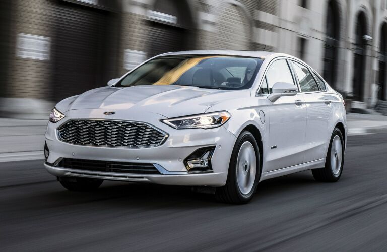 white 2019 ford fusion driving on city road