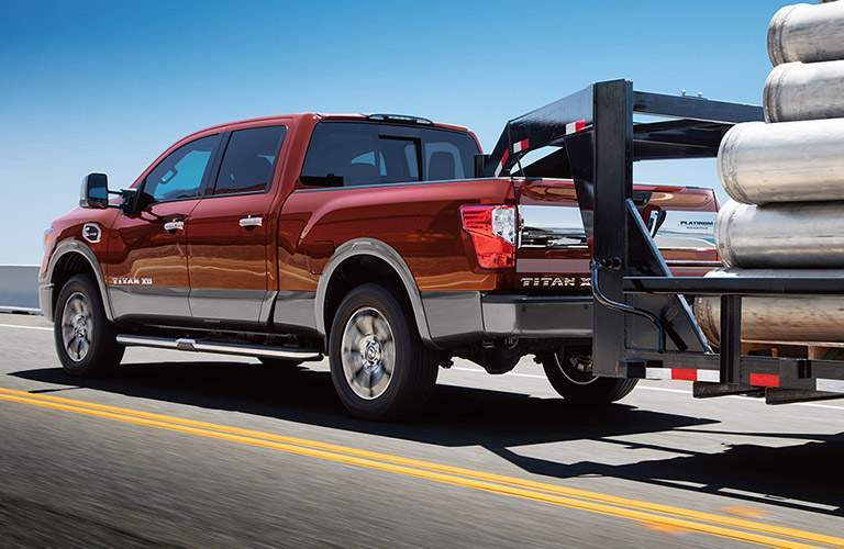 red 2017 nissan titan xd towing large cargo