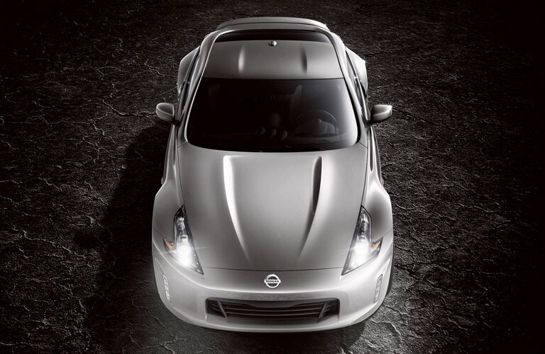 Exterior view of the top of a silver 2019 Nissan 370Z parked in a black showroom