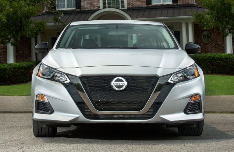 Exterior view of the front of a silver 2019 Nissan Altima parked outside a home