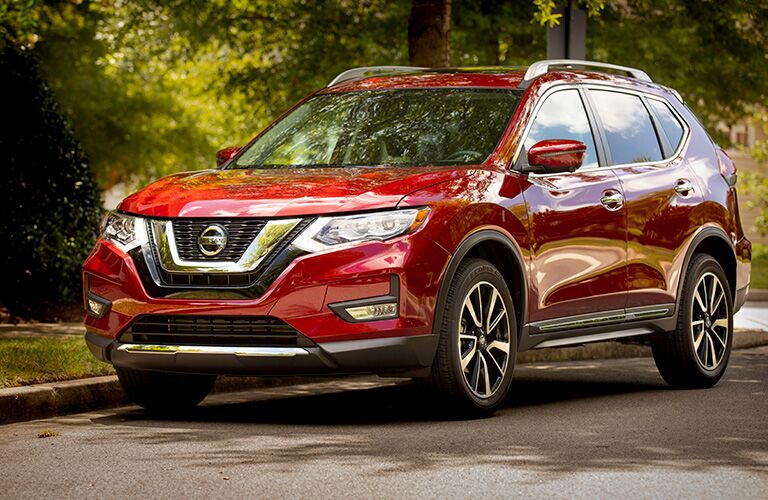 Exterior view of a red 2019 Nissan Rogue parked on a suburban street