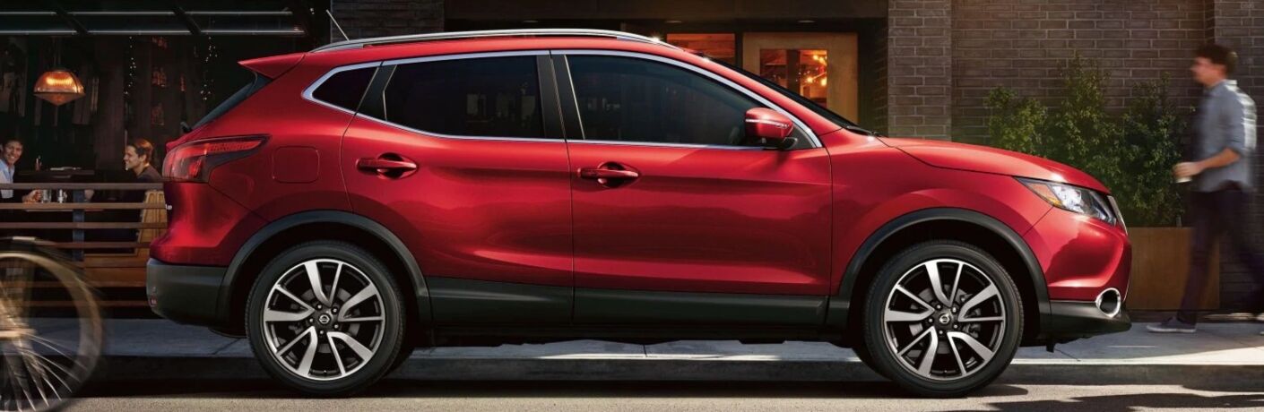 Exterior view of a red 2019 Nissan Rogue Sport parked on a city street