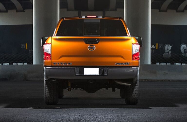 Exterior view of the rear of an orange 2019 Nissan TITAN parked in a parking garage