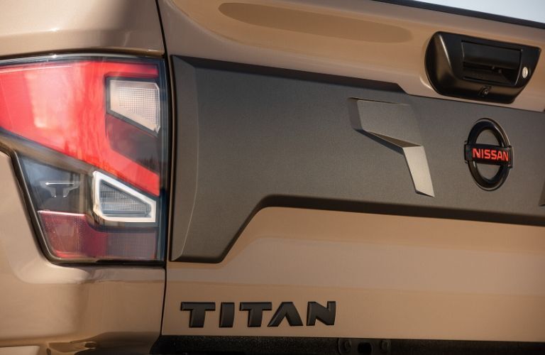 Closeup exterior view of the rear and "TITAN" badge on a tan 2020 Nissan TITAN