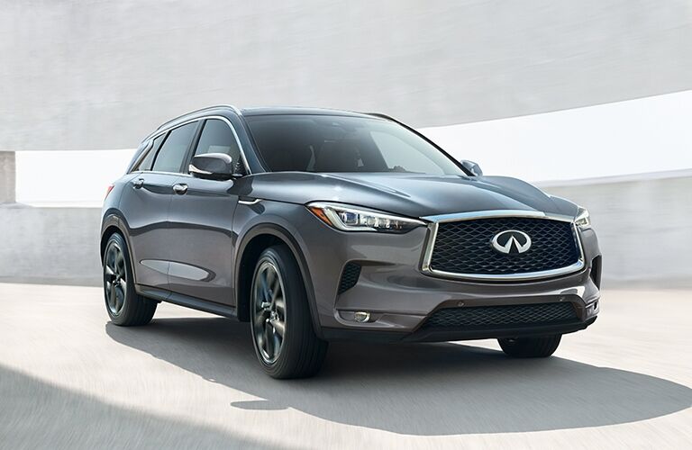 Exterior view of the front of a grey 2019 INFINITI QX50 driving inside a parking ramp