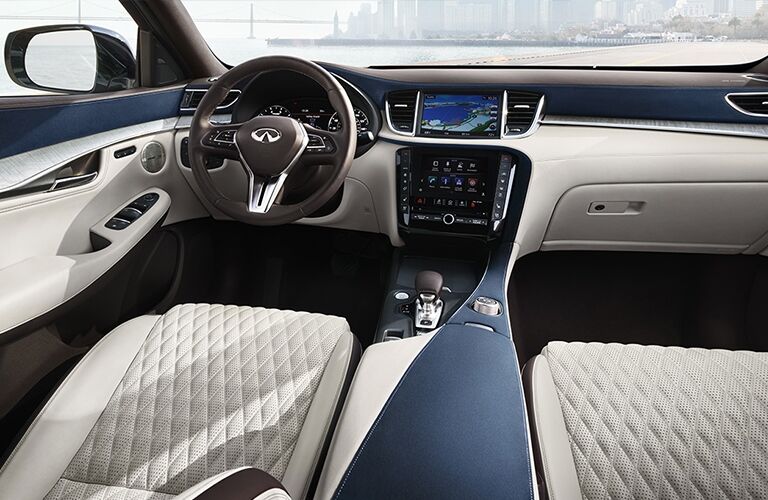 Interior view of the tan seating, black steering wheel, and touchscreen inside a 2019 INFINITI QX50