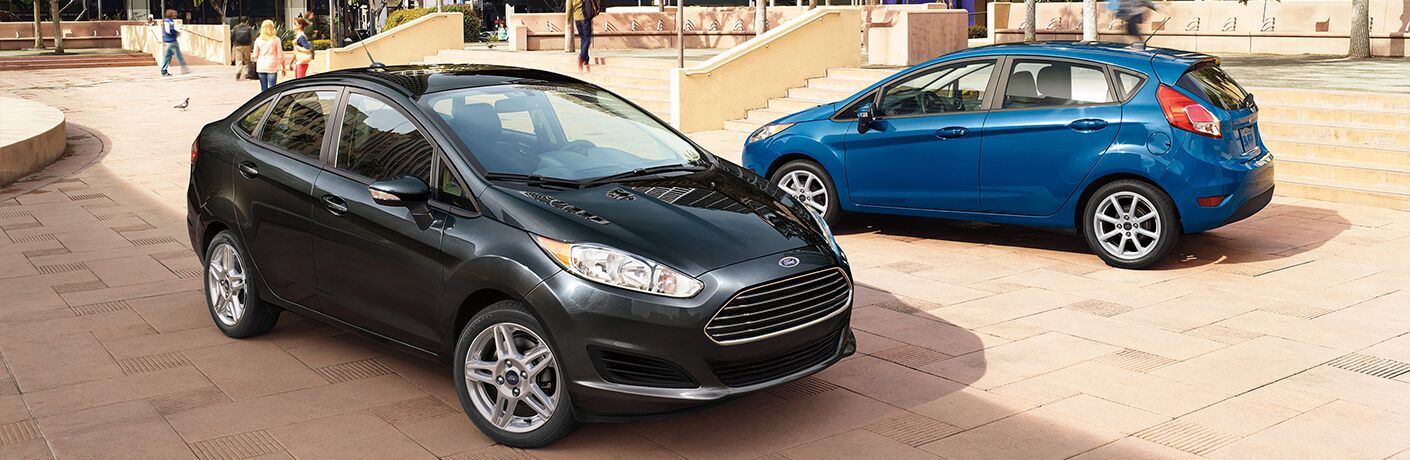 Sedan and hatchback models of the 2018 Ford Fiesta parked in a park