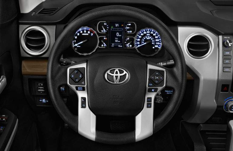 A close up photo of the steering wheel and center gauge cluster for the 2018 Toyota Tundra