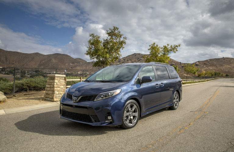 A front quarter view of a blue 2018 Toyota Sienna on a quiet street