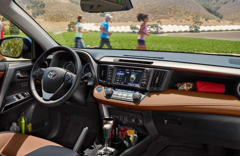 A view of the dashboard including the infotainment system and storage areas in the 2018 RAV4.