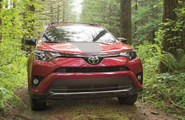 A head-on photo of the 2018 Toyota RAV4 Adventure driving through the woods.