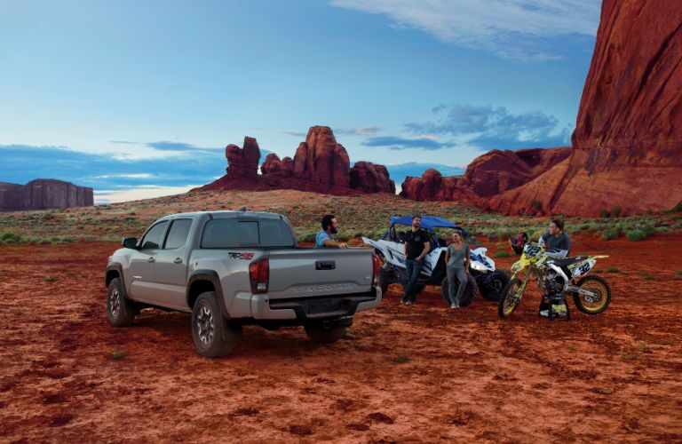 A photo of people standing near the 2018 Toyota Tacoma in the desert.