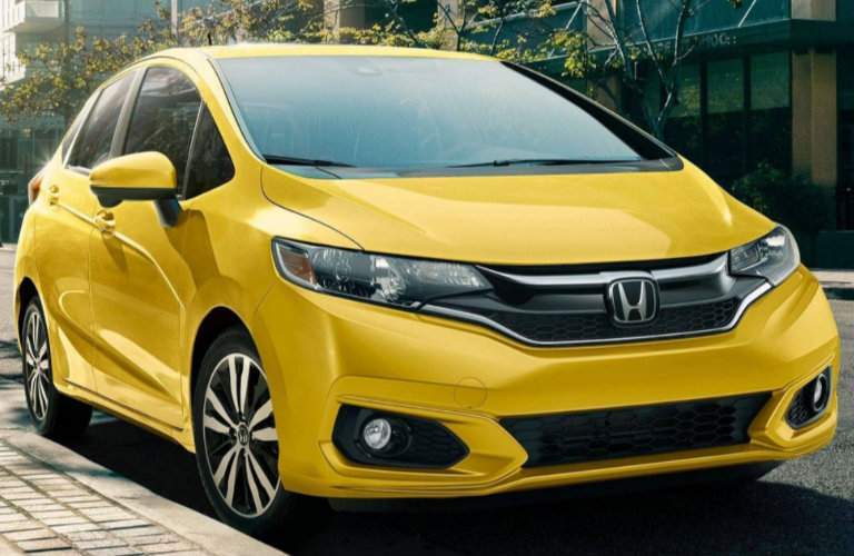 yellow 2018 Honda Fit driving in the city