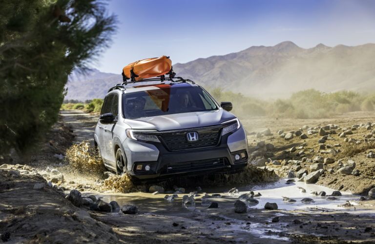 A photo of the 2021 Honda Passport driving through a puddle.