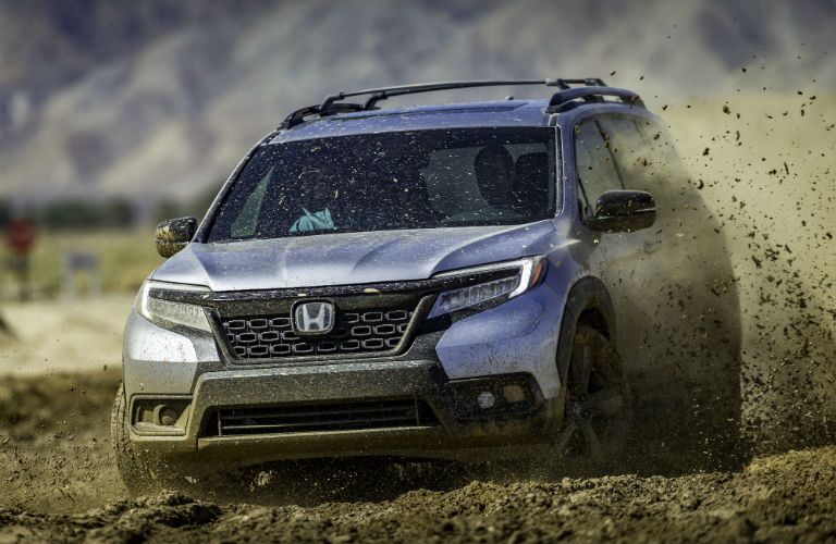 A photo of the 2019 Honda Passport driving through the mud.