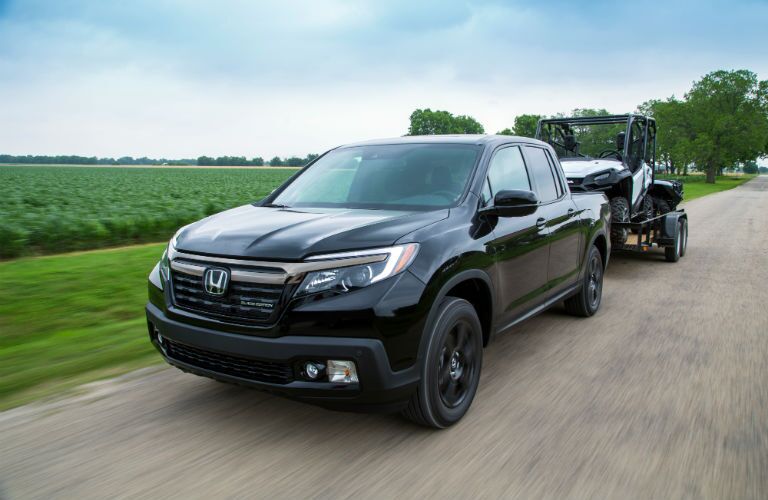 A photo of the 2020 Honda Ridgeline pulling a trailer down the road.