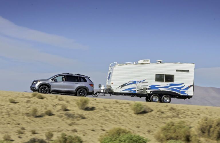 A photo of the 2021 Honda Passport towing a camper.
