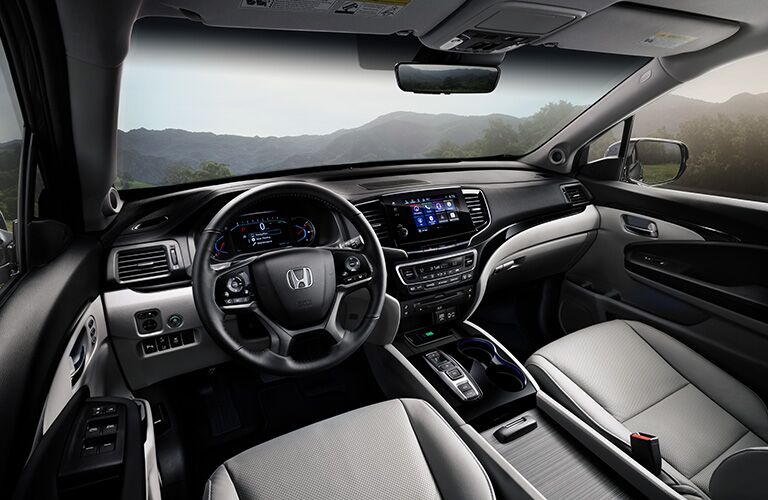 An interior photo of the 2019 Pilot showing the dashboard and front seats.