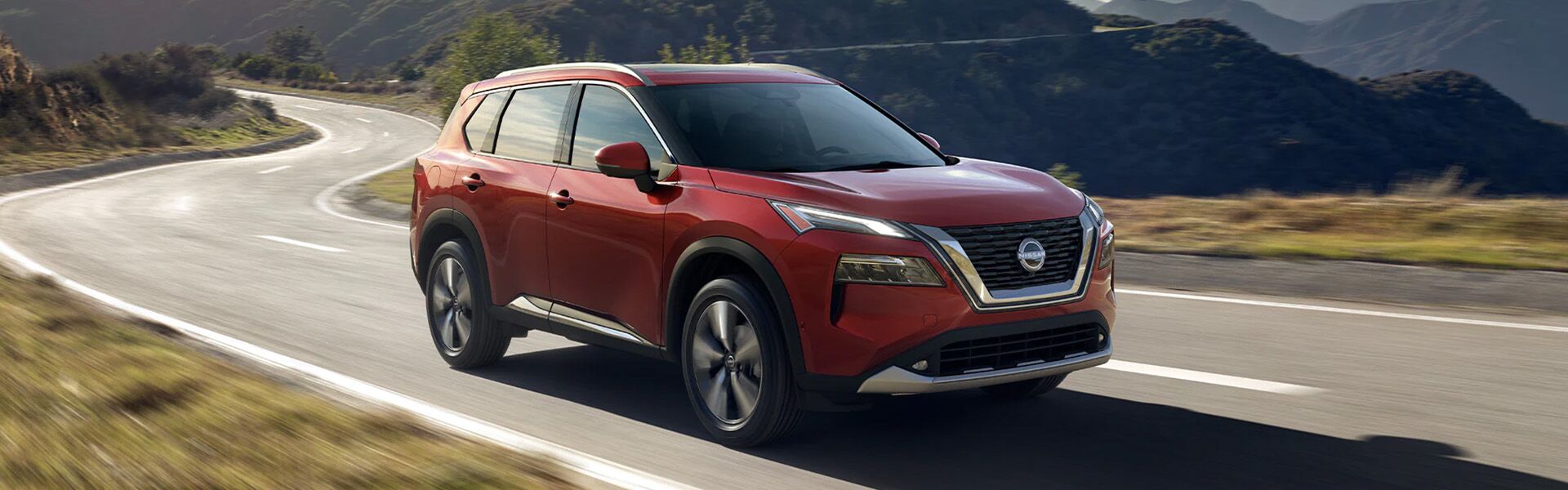 Side view of the 2023 Nissan Rogue on road Side view of the 2023 Nissan Rogue on road