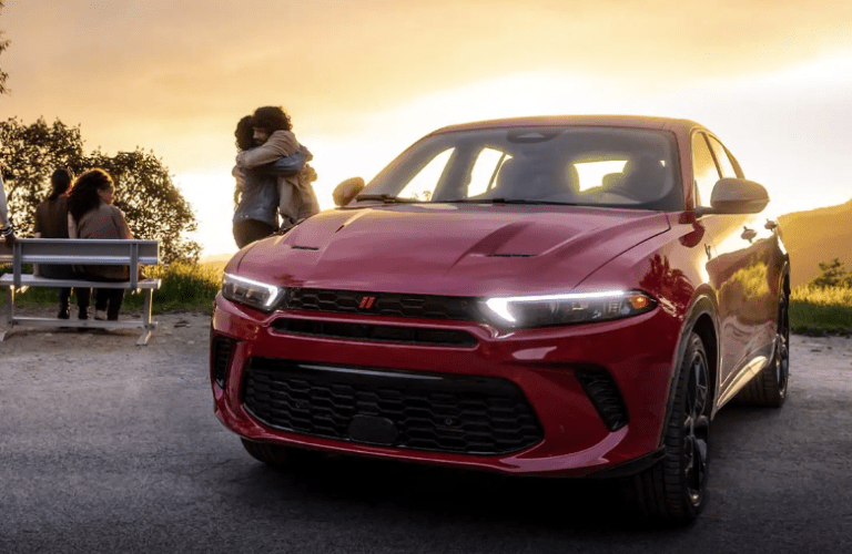Front view of the 2024 Dodge Hornet and a couple hugging near it