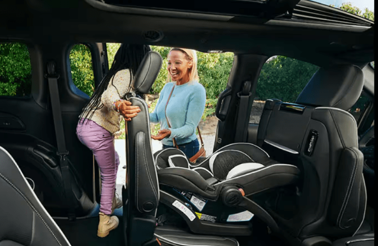 A kid coming out showcasing the Easy Tilt Seating of the 2025 Chrysler Pacifica.