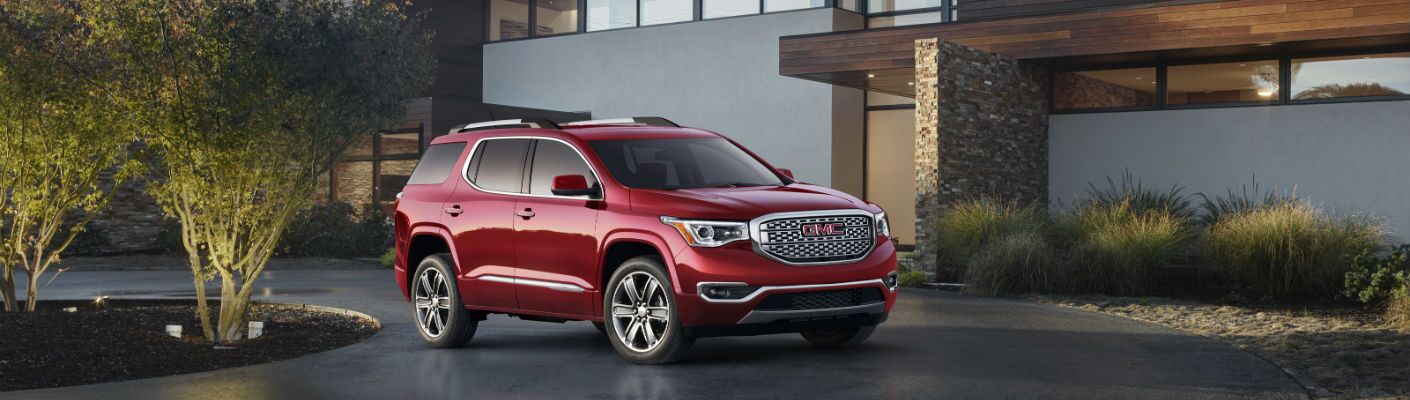 A photo of the Denali version of the 2019 GMC Acadia parked in a driveway.