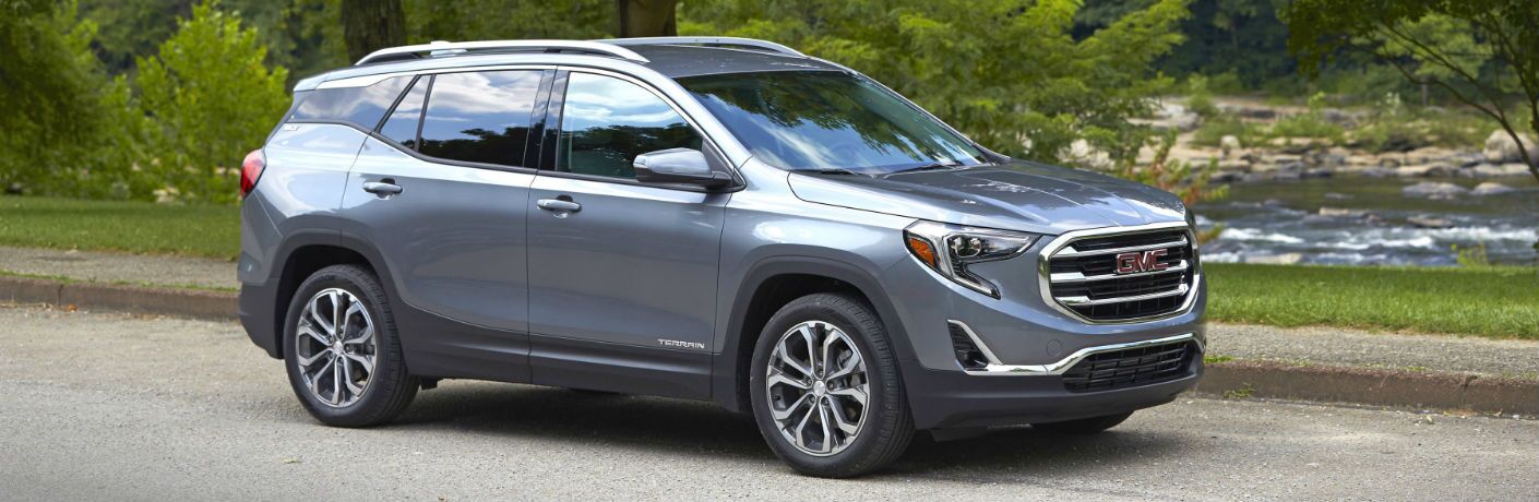 A right profile photo of the 2018 GMC Terrain parked in front of a river