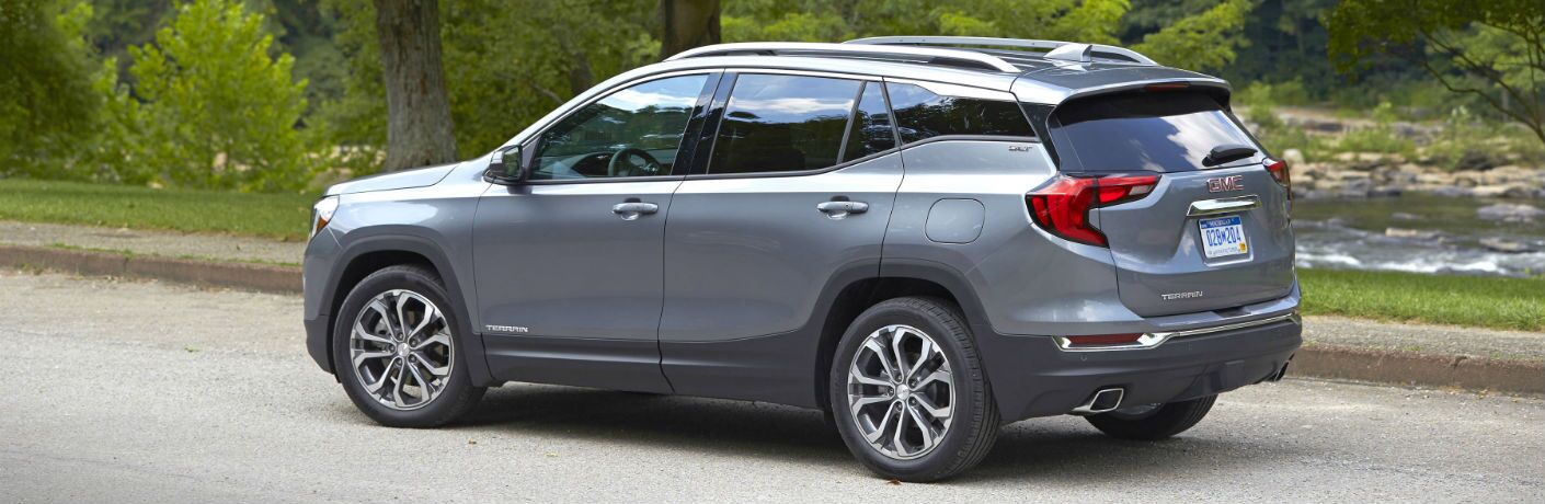 A left profile photo of the 2018 GMC Terrain parked in front of a river.