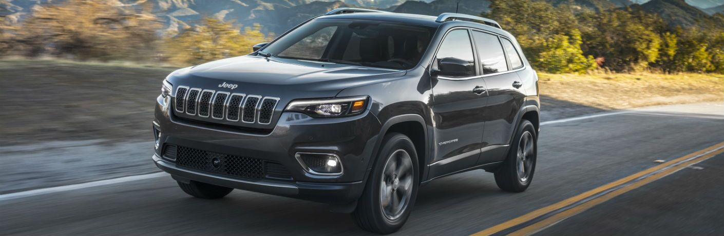 A front left quarter photo of the 2019 Jeep Cherokee in motion on a desert road.